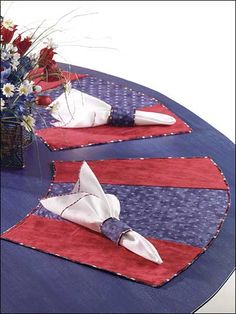 two red, white and blue placemats with napkins on them sitting on a table