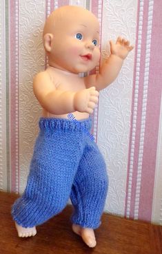 a baby doll is posed on a wooden table