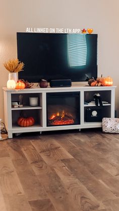 a living room with a fireplace and tv on it's stand in front of a wall