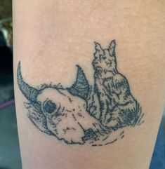 a cat and dog tattoo on the leg, with one sitting down next to another