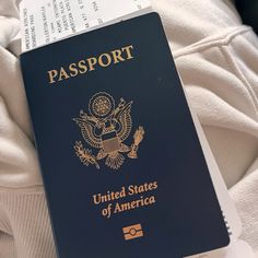 a united states passport sitting on top of someone's white shirt with an american flag