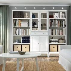 a living room filled with furniture and bookshelves next to a white couch in front of a window