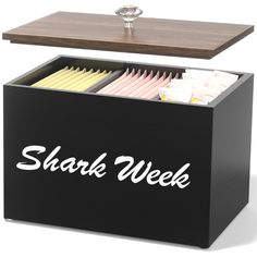 a wooden table with a black and white box on it that says, shark week