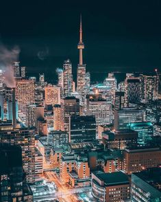 an aerial view of a city at night with the lights on and skyscrapers lit up