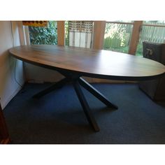 a wooden table sitting in front of a window