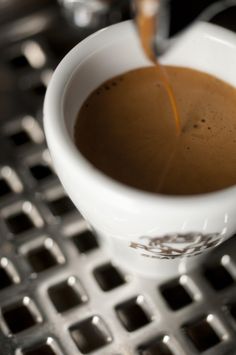 a cup of coffee being poured into it