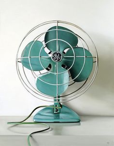 a green fan sitting on top of a table