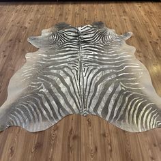 a zebra skin rug sitting on top of a wooden floor