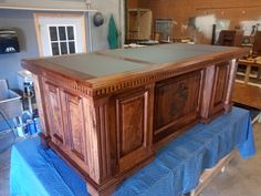 a large wooden table sitting on top of a blue cloth covered tablecloth in a room