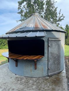 an old metal barrel with a wooden table in the center and open door on top