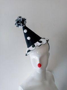 This beautiful Mini Clown hat is handmade with black twill fabric and polka dot cotton fabric for bottom ruffle. It has 2 white pom poms trim at center front and a handmade black/white big pom pom tops it off. It has adjustable movement  from side to side . It comes on a black headband that goes to 2 elastic loops, so you can slide it into any position on your head. It is comfortable to wear. Perfect to wear in a costume party or for a cosplay. (The headband is removable). Adult size. One size f Fun Black Hat For Costume Party, Fun Black Adjustable Costume Hats And Headpieces, Playful Adjustable Hats For Carnival, Playful Adjustable Mini Hats For Costumes, Playful Adjustable Mini Hats For Carnival, Playful Adjustable Hat For Carnival, Playful Black Adjustable Hat, Black And White Clown Outfit, Playful Adjustable Carnival Hat