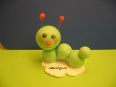 there is a small green toy that looks like a caterpillar on the table