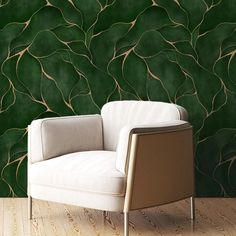 a white chair sitting in front of a green wall with vines on it's side