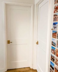 an open door in a white room with pictures on the wall and wood flooring