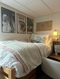 a bedroom with pictures on the wall above the bed