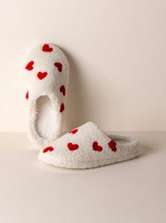 Your feet will thank you for kicking off your shoes and sliding into Shiraleah's Hearts Slippers. Closed toed and featuring a plush sherpa texture upon a rubber sole, these cozy house shoes are as sturdy as they are chic. The cute embroidered heart design adds a bit of playfulness to your new lounge wardrobe. Ribbon wrapped, this item makes a great gift option for yourself or others. Pair with other items from Shiraleah to complete the look! Color: Ivory S/M Fits Size 6-8, L/XL fits size 9-10 Po Slippers Aesthetic, Sherpa Texture, Vegan Packaging, Heart Slippers, Birthday 19, Christmas Slippers, Cute Slippers, Ribbon Wrap, Embroidered Heart