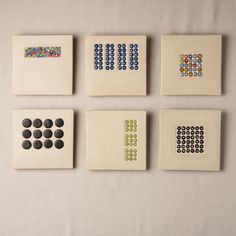 four ceramic tiles with different designs on them