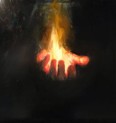 a person holding out their hands in front of a fire with the light shining on them