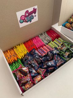 an open box filled with candy and pens