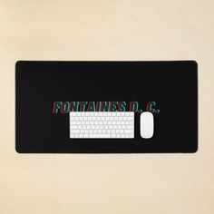 a computer mouse and keyboard sitting on top of a black mat that says fortanes d c