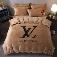 a bed with a louis vuitton comforter and pillows on top of it