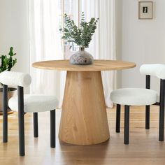 a wooden table with three chairs around it and a potted plant in the middle