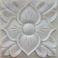 an intricately carved flower is shown on the wall in this tile pattern, which has been