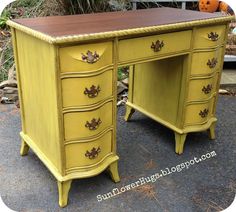 an old yellow desk with drawers and knobs on the top is sitting in front of some pumpkins