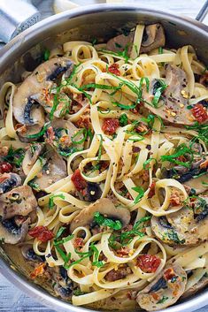 a pan filled with pasta and mushrooms on top of a table