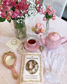 a table topped with pink flowers next to a tea pot