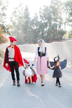 three people dressed in costumes are walking down the street with two children and one adult