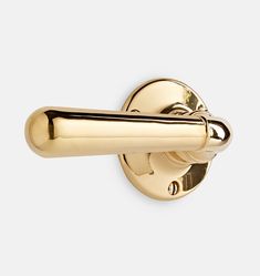 a gold door handle on a white wall