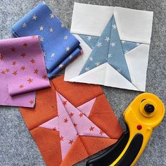 several different types of fabric and scissors on the ground next to each other, including one star