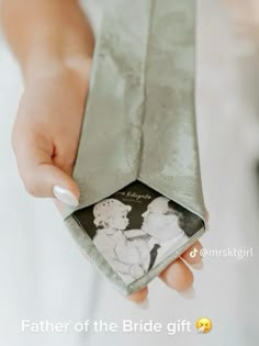 a woman is holding an old photo in her wedding day gift bag with the bride and groom on it