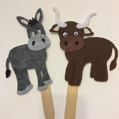 two animal puppets made out of felt on wooden sticks