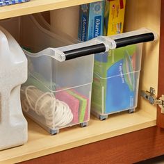 two plastic containers with cleaning products in them on a wooden shelf next to other items