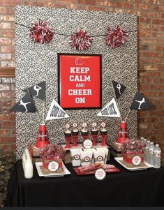 a table topped with lots of red and white items next to a brick wall filled with decorations