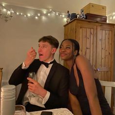 a man and woman sitting at a table drinking wine