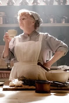 a woman in an apron holding a cup