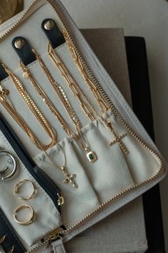 an assortment of gold jewelry is displayed in a white case with black trimmings