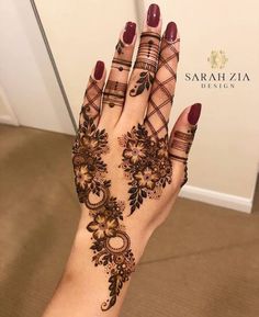 a woman's hand with henna tattoos on it