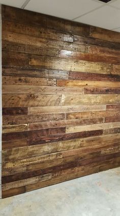 an unfinished room with wood paneling on the wall