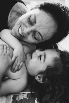 a man and woman laying on top of each other with their arms around each other