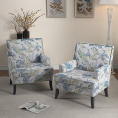 two blue chairs sitting next to each other on top of a carpeted room floor