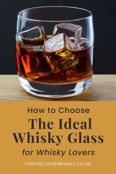 a glass filled with whisky on top of a wooden table