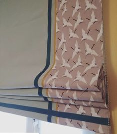 a curtain with birds on it hanging in front of a window