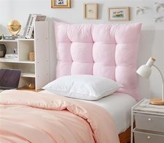 a pink headboard with white pillows in a bedroom