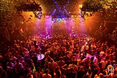 a large group of people at a party with confetti falling from the ceiling