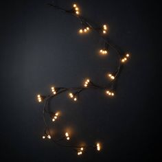 a string of christmas lights on a dark background with the light turned off to look like hearts