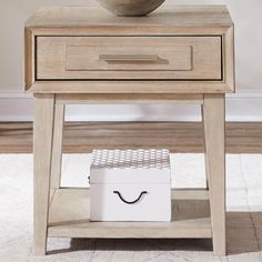 a bowl sitting on top of a wooden table next to a white box with a handle